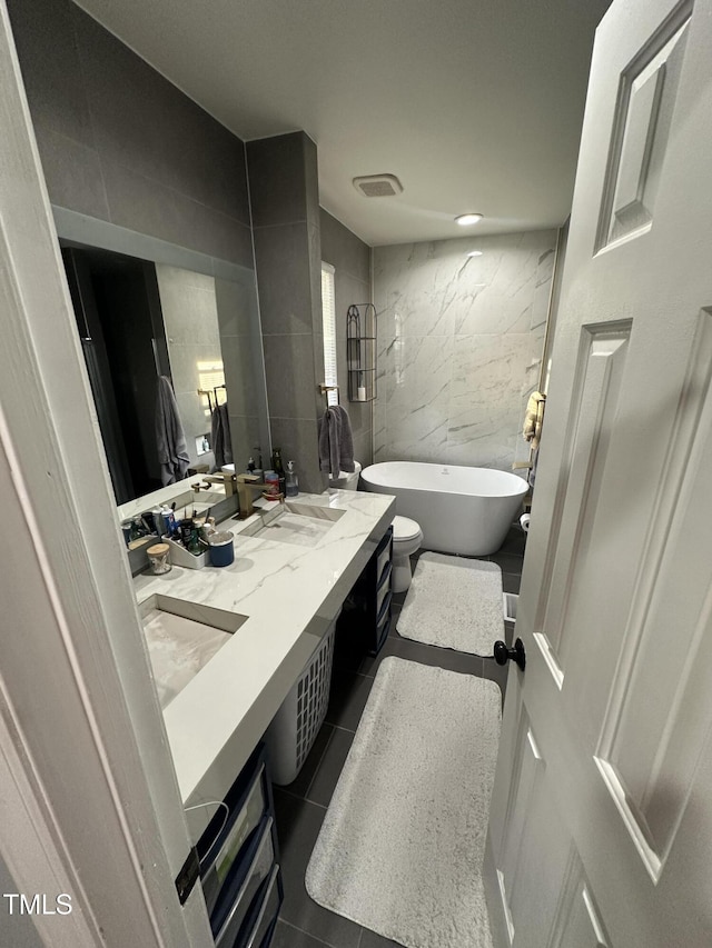 5809 Iris Lake Ct, Raleigh, NC 27604 - full bathroom featuring tile walls, a soaking tub, double vanity, and tile patterned flooring