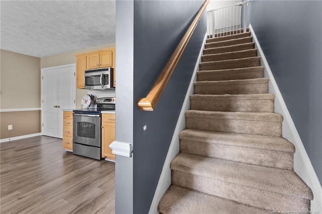 3117 Winesap Rd, Hope Mills, NC 28348 - stairs featuring wood finished floors and a textured ceiling