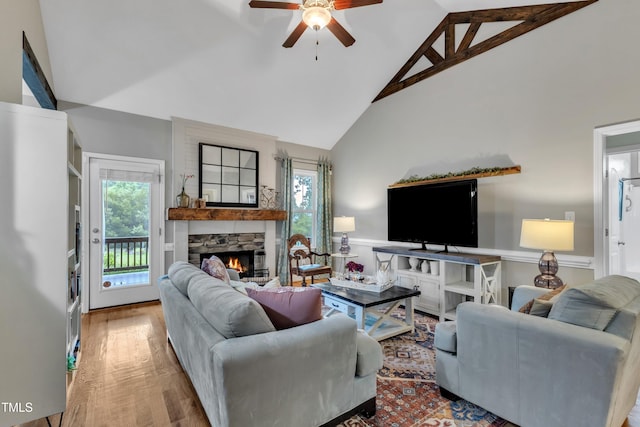 71 Smithsanders Ct, Smithfield, NC 27577 - living room with high vaulted ceiling, ceiling fan, a stone fireplace, wainscoting, and wood finished floors
