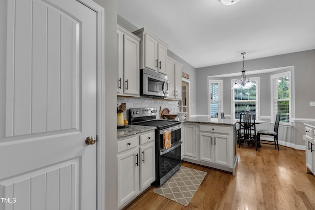 71 Smithsanders Ct, Smithfield, NC 27577 - kitchen featuring appliances with stainless steel finishes, a peninsula, light wood-type flooring, decorative backsplash, and white cabinetry