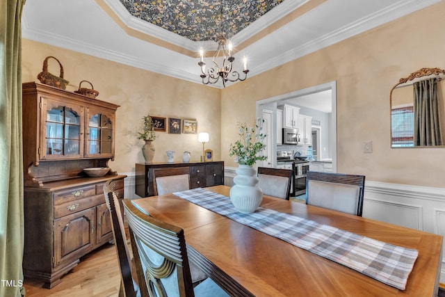 71 Smithsanders Ct, Smithfield, NC 27577 - dining room with a chandelier, crown molding, light wood-type flooring, a tray ceiling, and a wainscoted wall