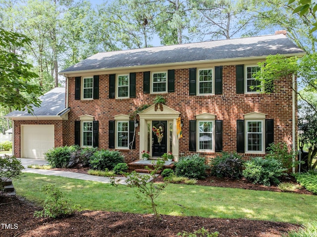 1304 Sandpiper Ct, Raleigh, NC 27615 - view of front facade featuring brick siding, a garage, a front yard, and roof with shingles