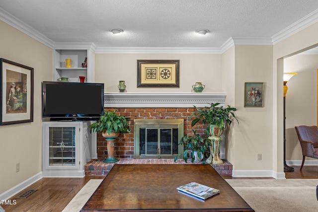 1304 Sandpiper Ct, Raleigh, NC 27615 - living area with ornamental molding, a fireplace, a textured ceiling, and wood finished floors