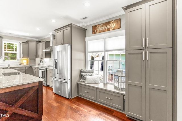 2218 Watersglen Dr, Apex, NC 27502 - kitchen with appliances with stainless steel finishes, gray cabinets, ornamental molding, light stone counters, and dark wood-style floors