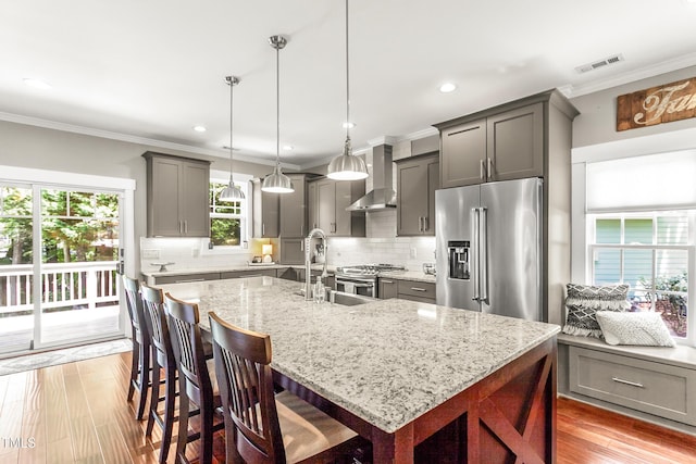 2218 Watersglen Dr, Apex, NC 27502 - kitchen with appliances with stainless steel finishes, wall chimney exhaust hood, gray cabinets, light stone counters, and backsplash