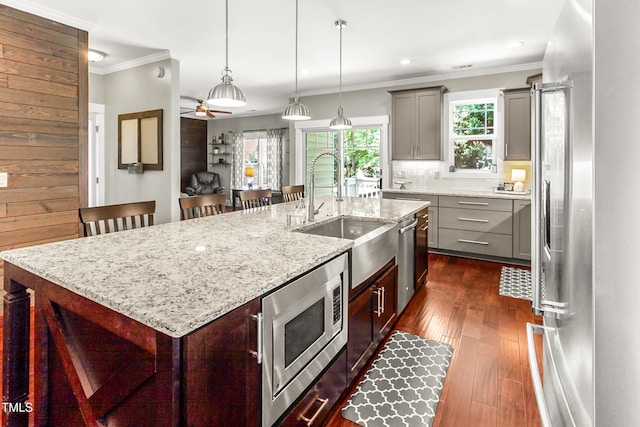 2218 Watersglen Dr, Apex, NC 27502 - kitchen with stainless steel appliances, gray cabinets, dark wood finished floors, ornamental molding, and ceiling fan