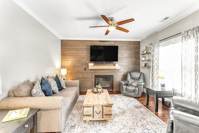 2218 Watersglen Dr, Apex, NC 27502 - living area featuring ceiling fan, crown molding, wooden walls, wood finished floors, and a glass covered fireplace