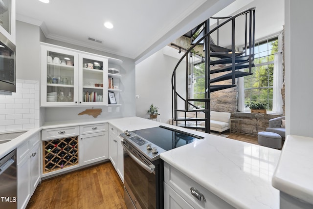 1500 River Mill Dr Unit 310, Wake Forest, NC 27587 - kitchen with appliances with stainless steel finishes, crown molding, wood finished floors, glass insert cabinets, and white cabinetry