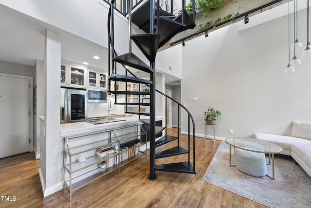 1500 River Mill Dr Unit 310, Wake Forest, NC 27587 - stairway featuring wood finished floors, a high ceiling, and recessed lighting