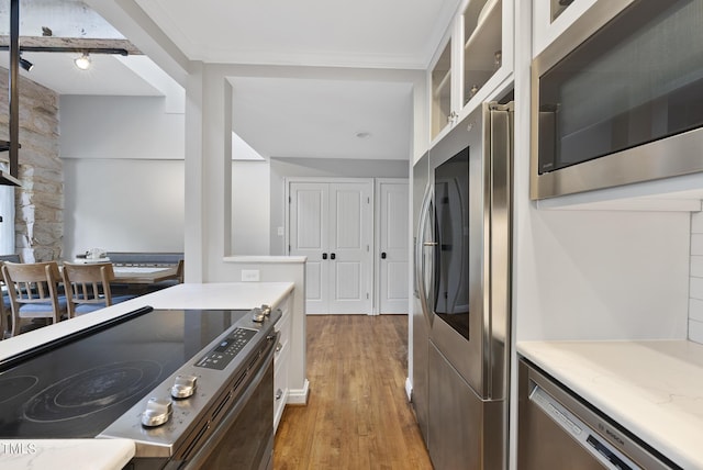 1500 River Mill Dr Unit 310, Wake Forest, NC 27587 - kitchen with stainless steel appliances, light wood-type flooring, white cabinetry, light countertops, and glass insert cabinets
