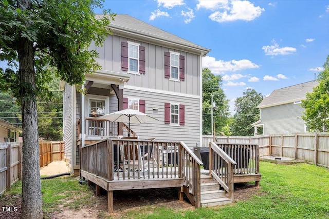 1304 Castlebay Rd, Durham, NC 27703 - back of property with board and batten siding, a fenced backyard, and a deck