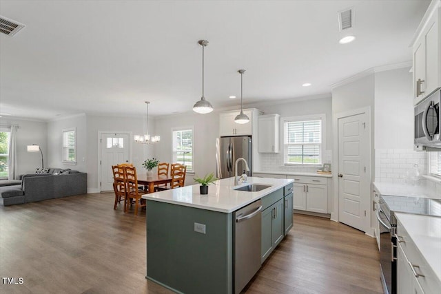1304 Castlebay Rd, Durham, NC 27703 - kitchen with appliances with stainless steel finishes, open floor plan, recessed lighting, white cabinets, and crown molding