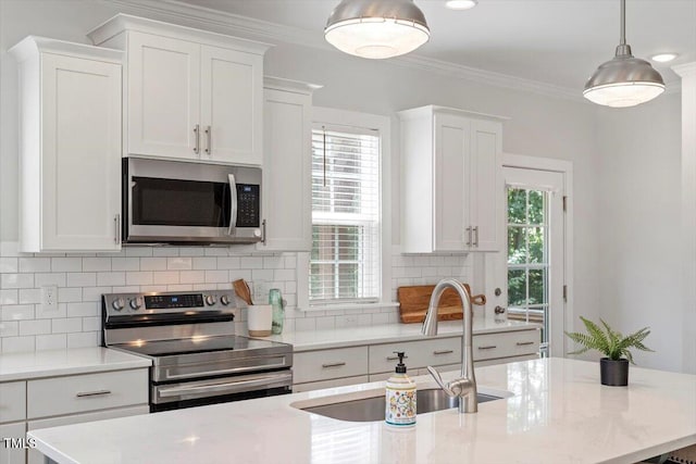 1304 Castlebay Rd, Durham, NC 27703 - kitchen with stainless steel appliances, white cabinetry, ornamental molding, tasteful backsplash, and hanging light fixtures