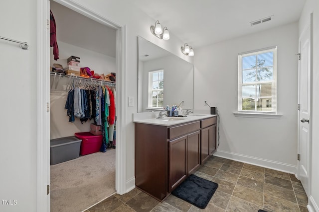 120 Misty Grove Trl, Franklinton, NC 27525 - bathroom featuring healthy amount of natural light, double vanity, a spacious closet, and stone finish floors