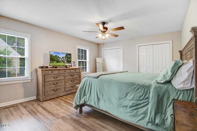 204 Paul Pl, Goldsboro, NC 27534 - bedroom featuring multiple closets, light wood-style flooring, ceiling fan, and a textured ceiling