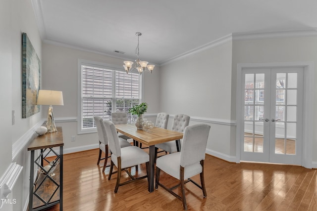 413 Westfalen Dr, Cary, NC 27519 - dining area with ornamental molding, wood finished floors, a chandelier, and french doors