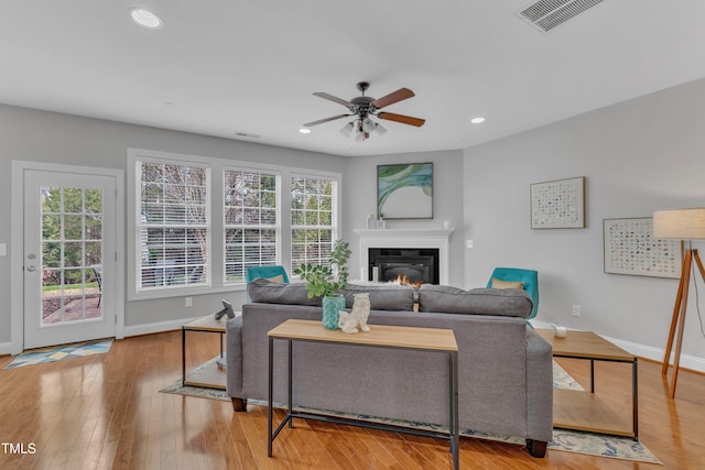 413 Westfalen Dr, Cary, NC 27519 - living room with ceiling fan, recessed lighting, a glass covered fireplace, and wood finished floors