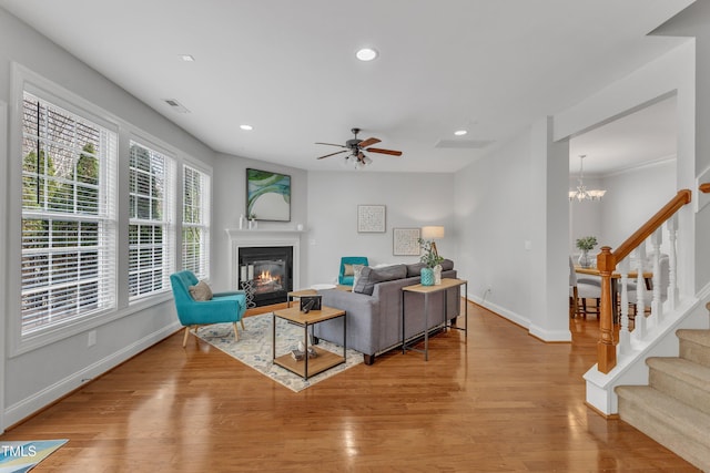 413 Westfalen Dr, Cary, NC 27519 - living room with wood finished floors, a glass covered fireplace, recessed lighting, ceiling fan, and stairway