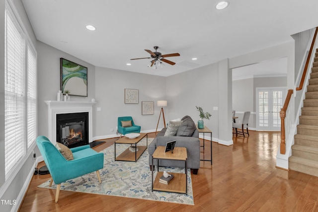 413 Westfalen Dr, Cary, NC 27519 - living area featuring stairway, a glass covered fireplace, ceiling fan, recessed lighting, and wood finished floors