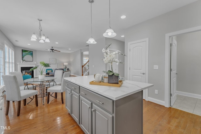 413 Westfalen Dr, Cary, NC 27519 - kitchen with gray cabinetry, a chandelier, light wood-style floors, a kitchen island, and open floor plan