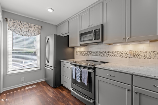 1815 Crystal Downs Ln, Raleigh, NC 27604 - kitchen with appliances with stainless steel finishes, gray cabinetry, tasteful backsplash, dark wood-style flooring, and light stone countertops