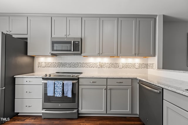 1815 Crystal Downs Ln, Raleigh, NC 27604 - kitchen featuring stainless steel appliances, gray cabinetry, tasteful backsplash, light stone counters, and dark wood-style floors