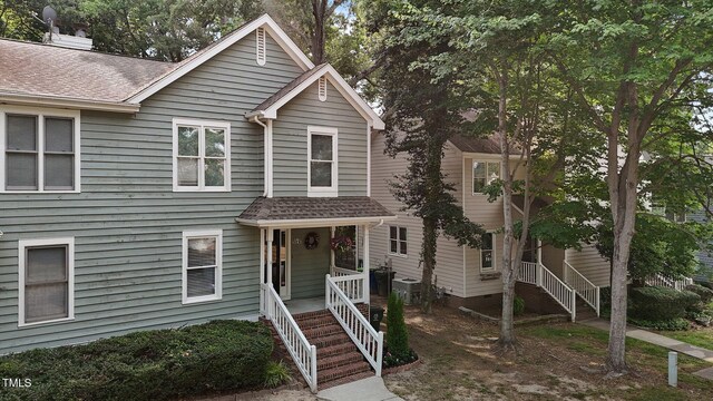 1815 Crystal Downs Ln, Raleigh, NC 27604 - view of front facade with covered porch, a shingled roof, and a chimney