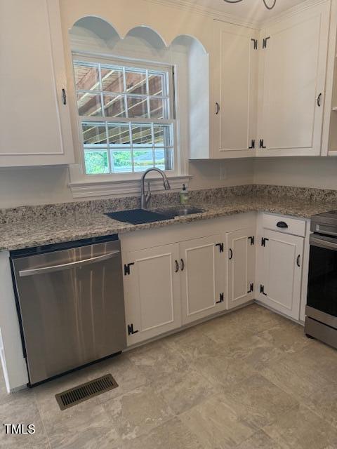 403 Rodwell St, Warrenton, NC 27589 - kitchen with stainless steel appliances, white cabinetry, light stone counters, and crown molding