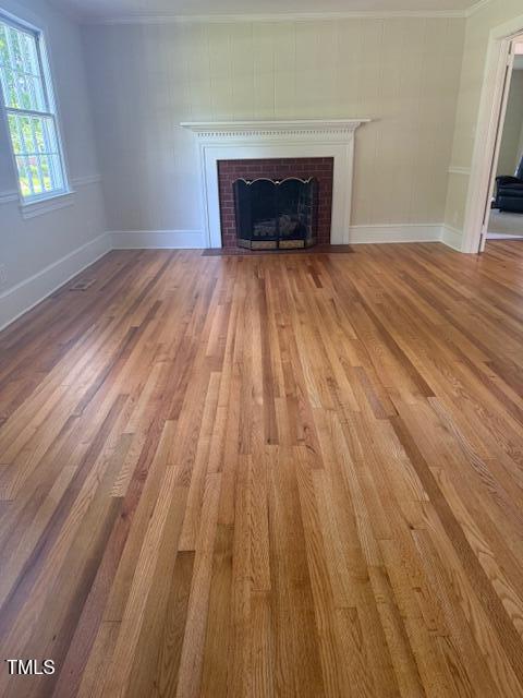 403 Rodwell St, Warrenton, NC 27589 - unfurnished living room featuring a fireplace with flush hearth, wood finished floors, and ornamental molding