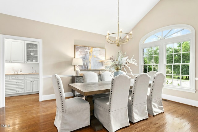 5204 Winter Holly Ct, Raleigh, NC 27606 - dining area featuring a chandelier, plenty of natural light, lofted ceiling, and light wood-style flooring