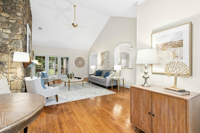 5204 Winter Holly Ct, Raleigh, NC 27606 - living area with high vaulted ceiling, arched walkways, light wood-style floors, and a ceiling fan