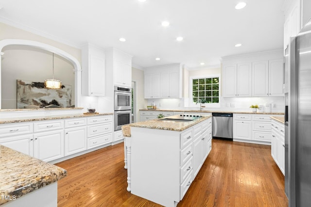 5204 Winter Holly Ct, Raleigh, NC 27606 - kitchen with appliances with stainless steel finishes, crown molding, light wood-style flooring, white cabinetry, and recessed lighting