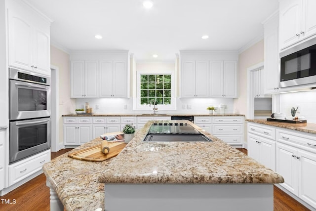 5204 Winter Holly Ct, Raleigh, NC 27606 - kitchen featuring stainless steel double oven, built in microwave, a center island, white cabinetry, and tasteful backsplash