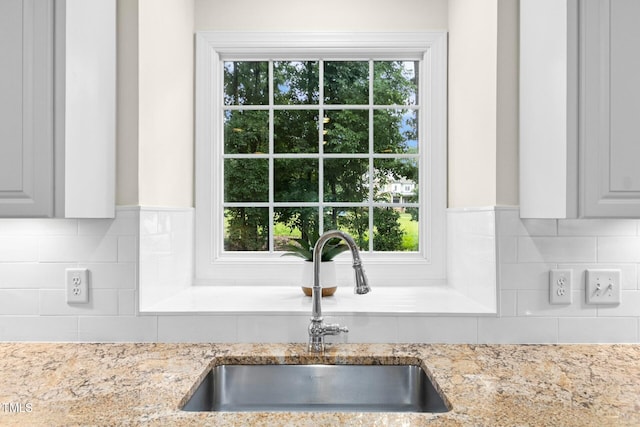 5204 Winter Holly Ct, Raleigh, NC 27606 - kitchen with backsplash, plenty of natural light, and light stone countertops
