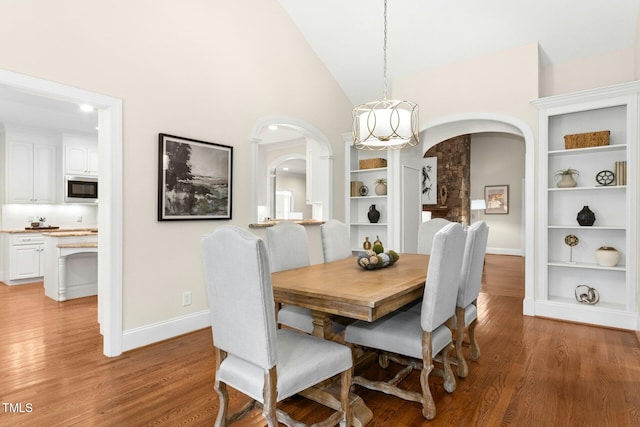 5204 Winter Holly Ct, Raleigh, NC 27606 - dining space with arched walkways, light wood finished floors, and high vaulted ceiling