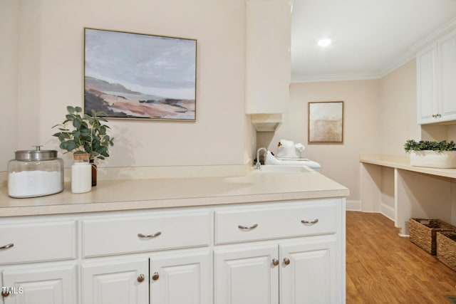 5204 Winter Holly Ct, Raleigh, NC 27606 - kitchen with ornamental molding, light wood-type flooring, white cabinets, and light countertops