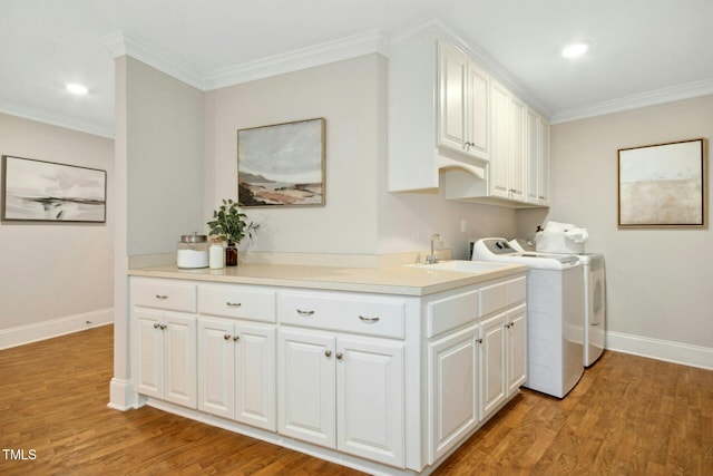5204 Winter Holly Ct, Raleigh, NC 27606 - washroom featuring washer and clothes dryer, cabinet space, light wood-style flooring, crown molding, and recessed lighting