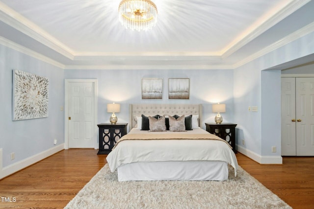 5204 Winter Holly Ct, Raleigh, NC 27606 - bedroom with a raised ceiling, wood finished floors, crown molding, and a chandelier