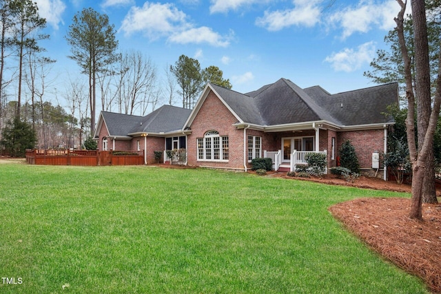 5204 Winter Holly Ct, Raleigh, NC 27606 - back of house with brick siding, a porch, a yard, and roof with shingles