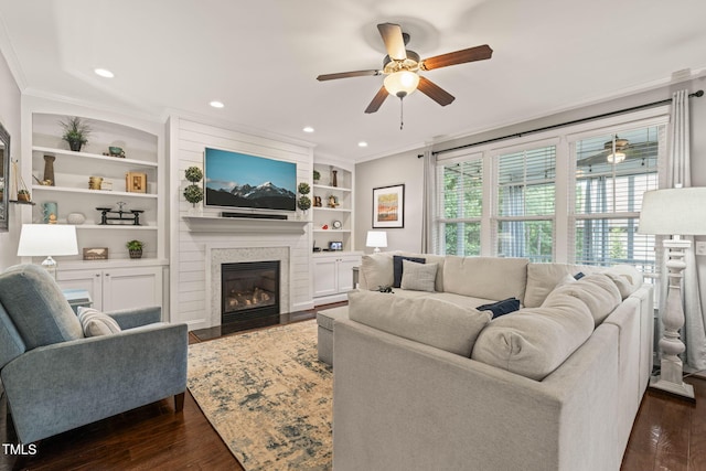 508 Morning Oaks Dr, Holly Springs, NC 27540 - living room featuring ceiling fan, crown molding, dark wood-style flooring, a large fireplace, and built in features