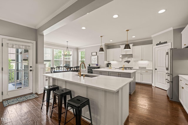 508 Morning Oaks Dr, Holly Springs, NC 27540 - kitchen with appliances with stainless steel finishes, an island with sink, dark wood finished floors, a kitchen breakfast bar, and tasteful backsplash