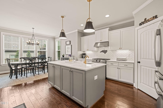 508 Morning Oaks Dr, Holly Springs, NC 27540 - kitchen featuring under cabinet range hood, backsplash, crown molding, dark wood-type flooring, and recessed lighting