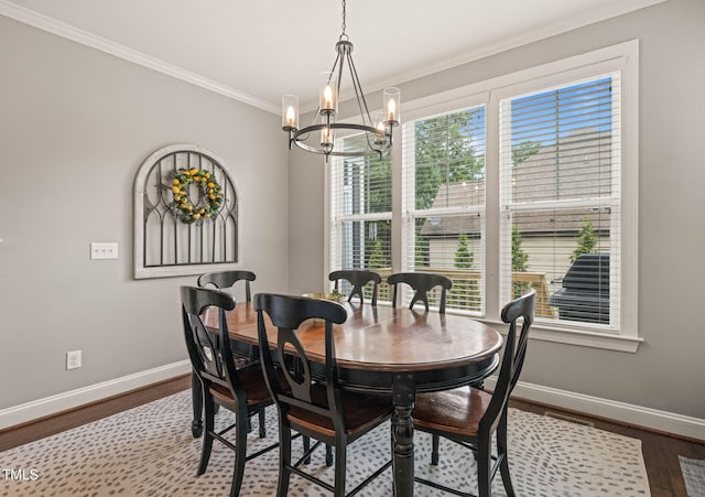 508 Morning Oaks Dr, Holly Springs, NC 27540 - dining area with a chandelier, crown molding, and dark wood-style flooring