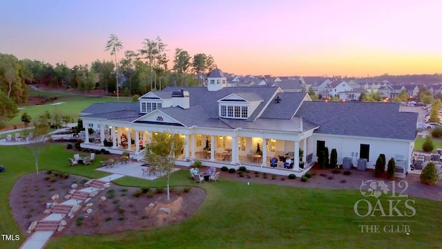 508 Morning Oaks Dr, Holly Springs, NC 27540 - back of property at dusk featuring a yard, a patio, a residential view, and a porch