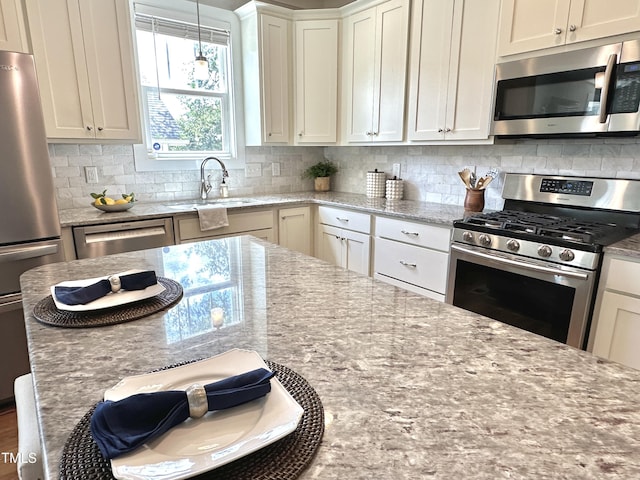 118 Chestnut St, Durham, NC 27707 - kitchen with stainless steel appliances, backsplash, light stone countertops, and white cabinets