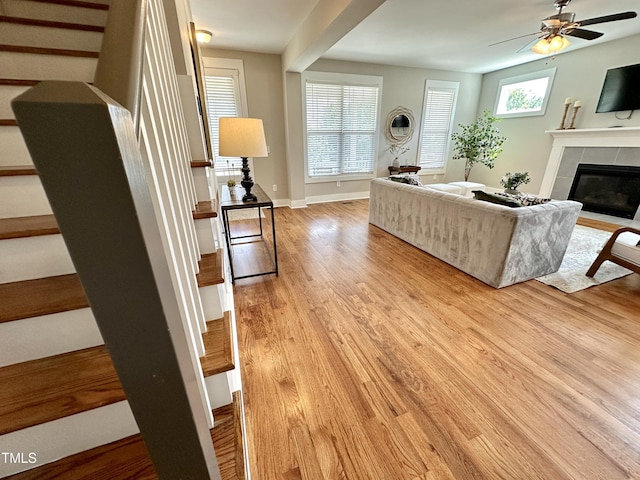 118 Chestnut St, Durham, NC 27707 - living area with light wood-style floors, a fireplace with flush hearth, stairway, and ceiling fan