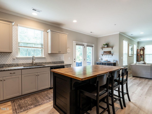 857 Stable Fern Dr, Fuquay Varina, NC 27526 - kitchen featuring butcher block countertops, dishwashing machine, light wood-type flooring, backsplash, and healthy amount of natural light
