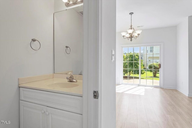 8326 Glenwood Springs Ct, Raleigh, NC 27616 - bathroom with a chandelier, vanity, and wood finished floors