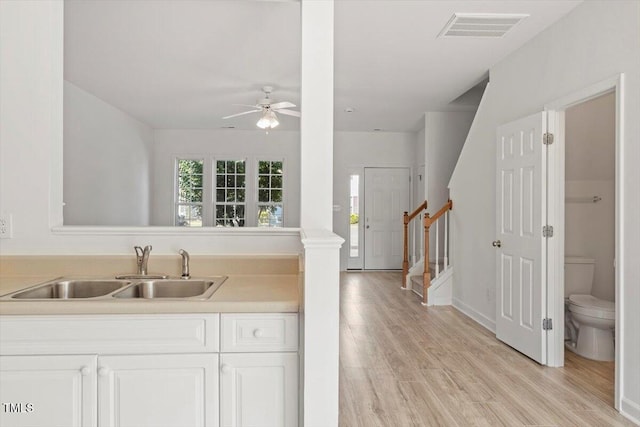 8326 Glenwood Springs Ct, Raleigh, NC 27616 - kitchen featuring ceiling fan, light countertops, light wood-type flooring, and white cabinets