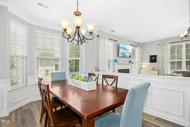 304 Forbes Rd, Wake Forest, NC 27587 - dining area featuring a chandelier, dark wood-style floors, a wainscoted wall, a decorative wall, and a fireplace
